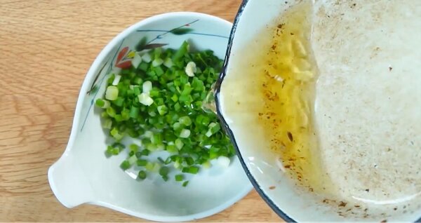 Rót dầu nóng vào hành lá đã thái nhỏ